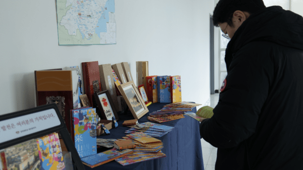 现场嘉宾在“山东特色非遗与文创展品区”翻阅东营《孙子兵法》书籍(摄影=李好)